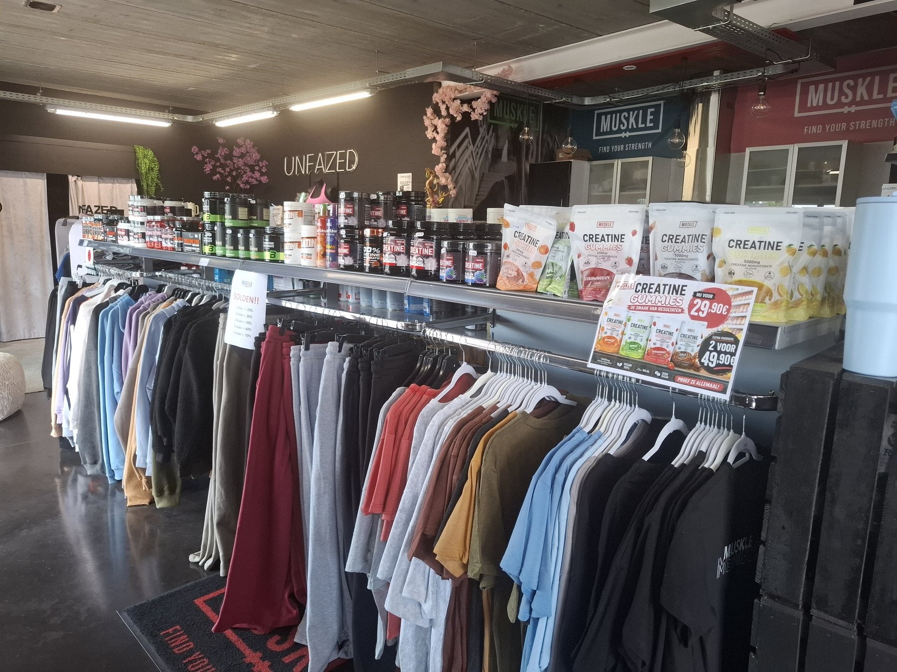 Creatine-gummiesdisplay naast kledingrekken bij MUSKLE Bonheiden
