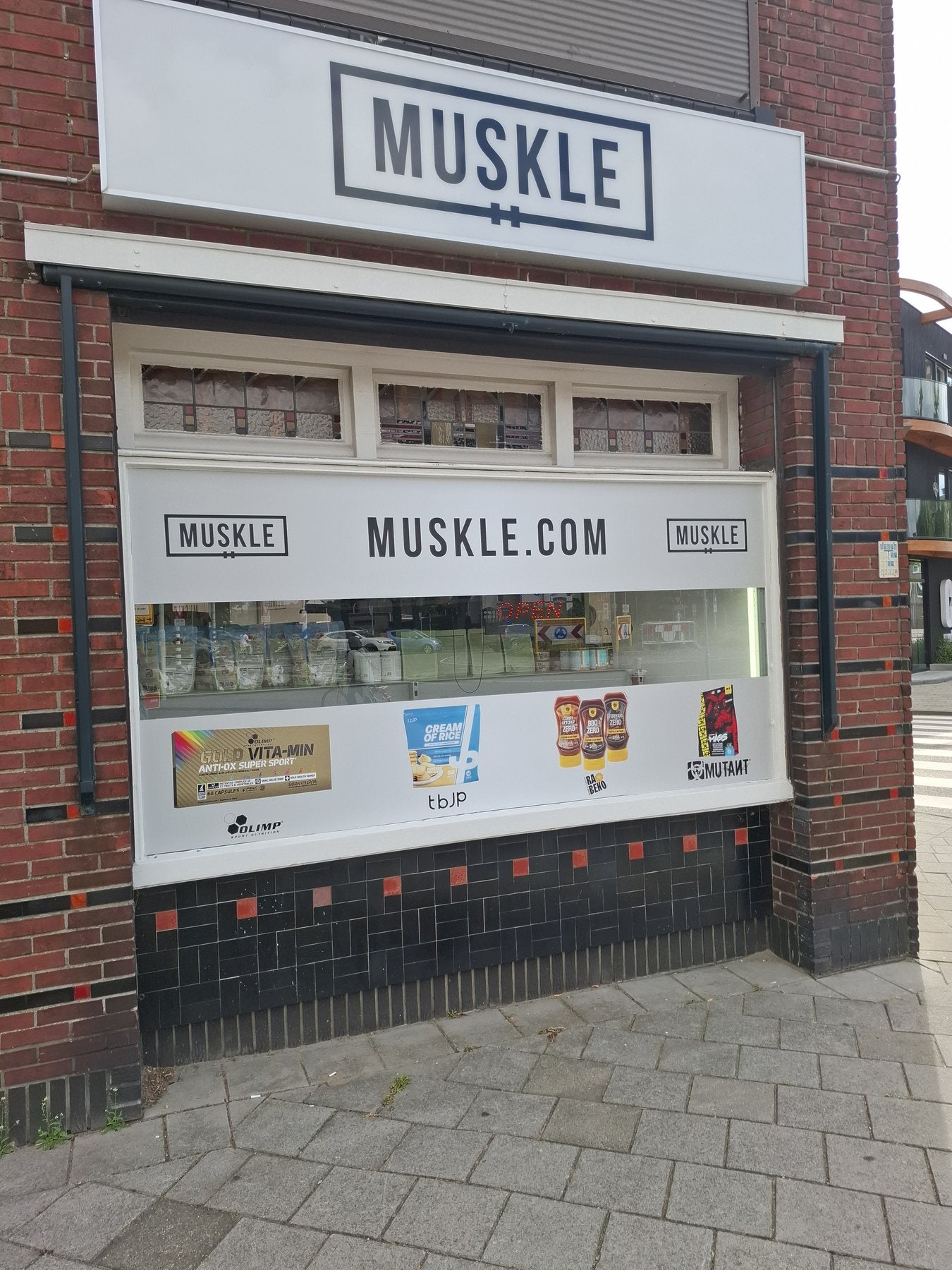 Etalage van MUSKLE Roosendaal met MUSKLE-bord en OPEN-bord